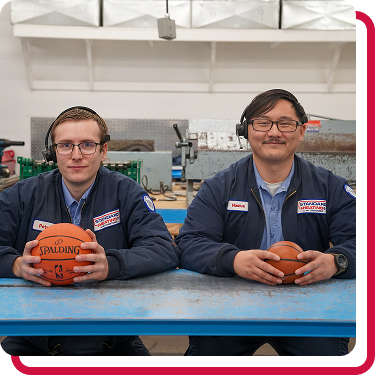 Men holding basketballs in Standard Heating & Air Conditioning uniforms